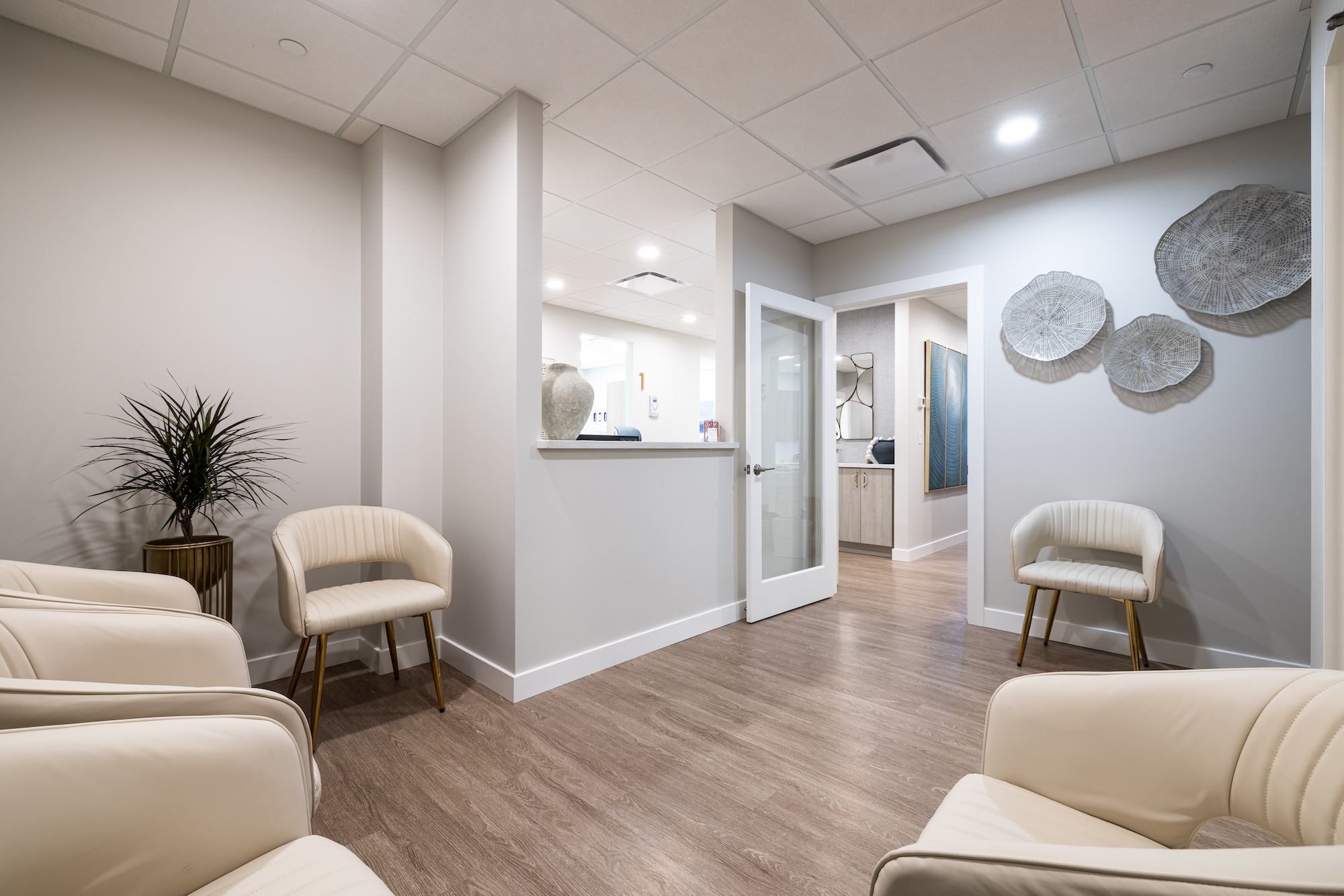 The image shows an interior space, likely a waiting room or lobby, with neutral tones and modern furnishings.