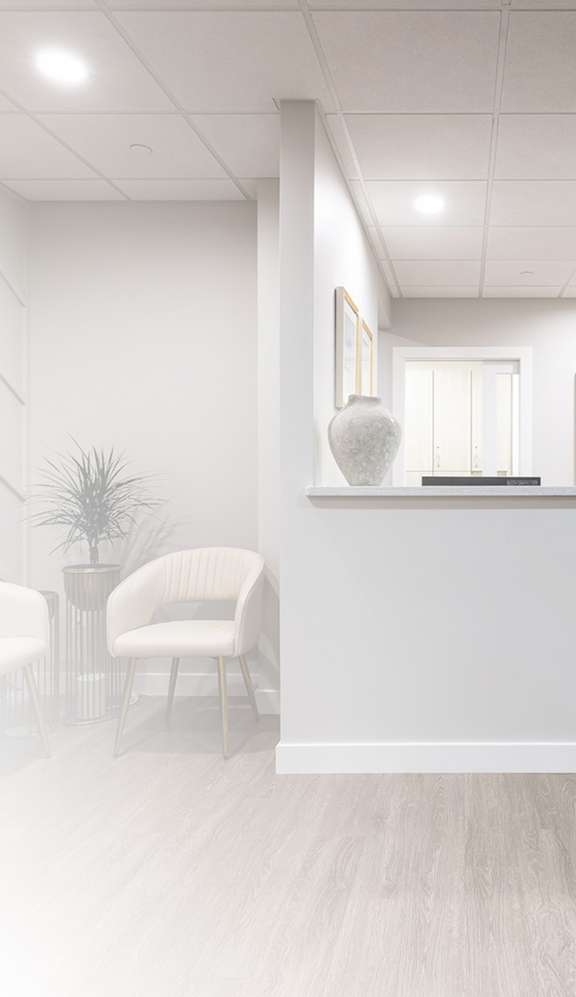 The image shows a modern dental or medical office interior with a dental chair, equipment, and a clean, professional environment.